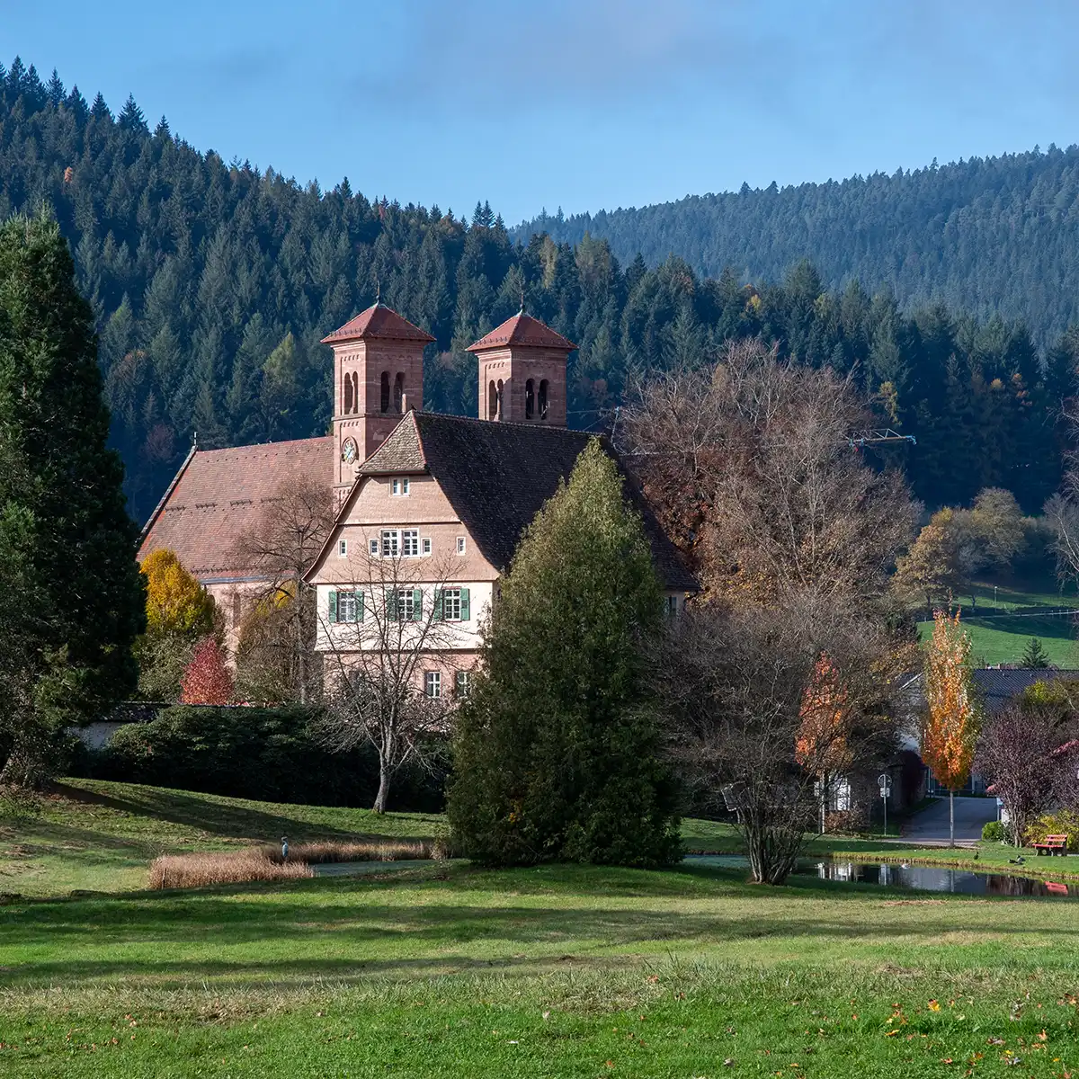 Historische Kirche Kloster Reichenbach mit Türmen und Wasserspielen im gepflegten Park.